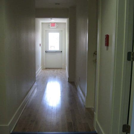 An empty hallway with plain walls and no furniture or people visible.