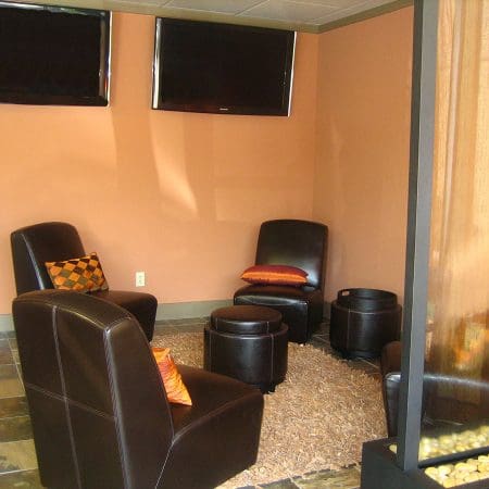 A cozy room featuring leather chairs arranged around a television.